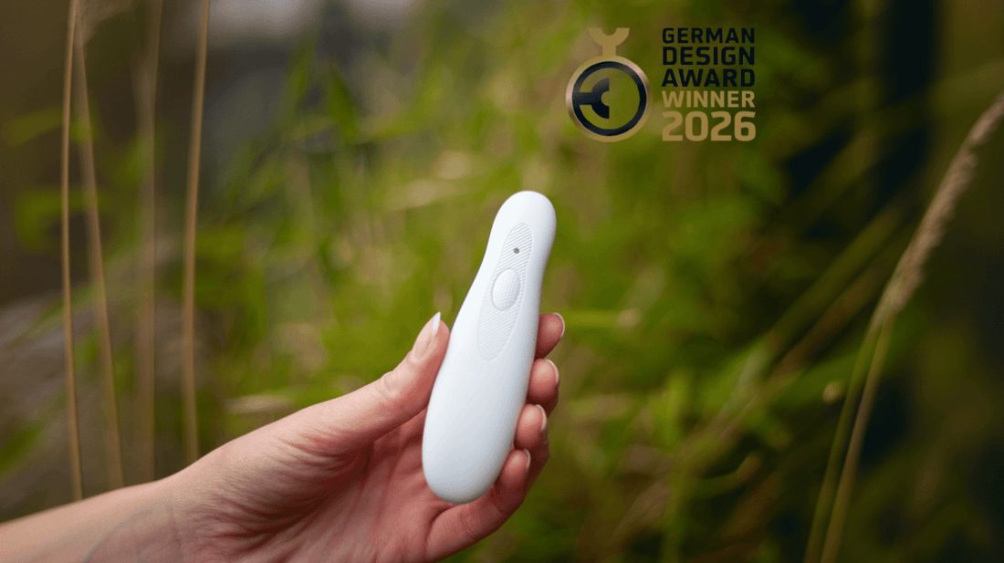 Hand hält einen weißen IEA Medical Insektenstichheiler vor unscharfem Grün im Freien, mit „German Design Award Winner 2026“-Hinweis oben rechts.