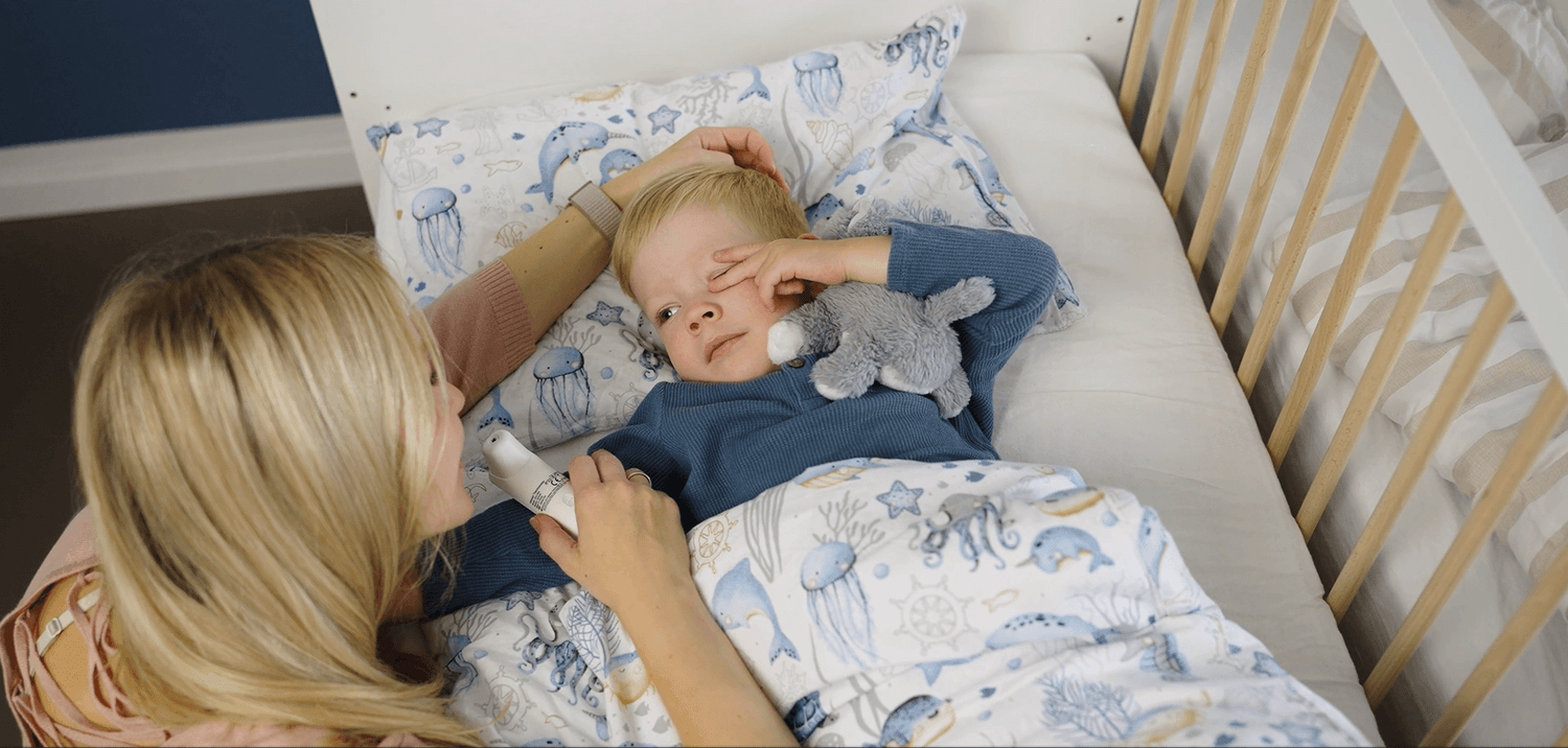 Mutter misst Fieber bei schläfrigem Kind
