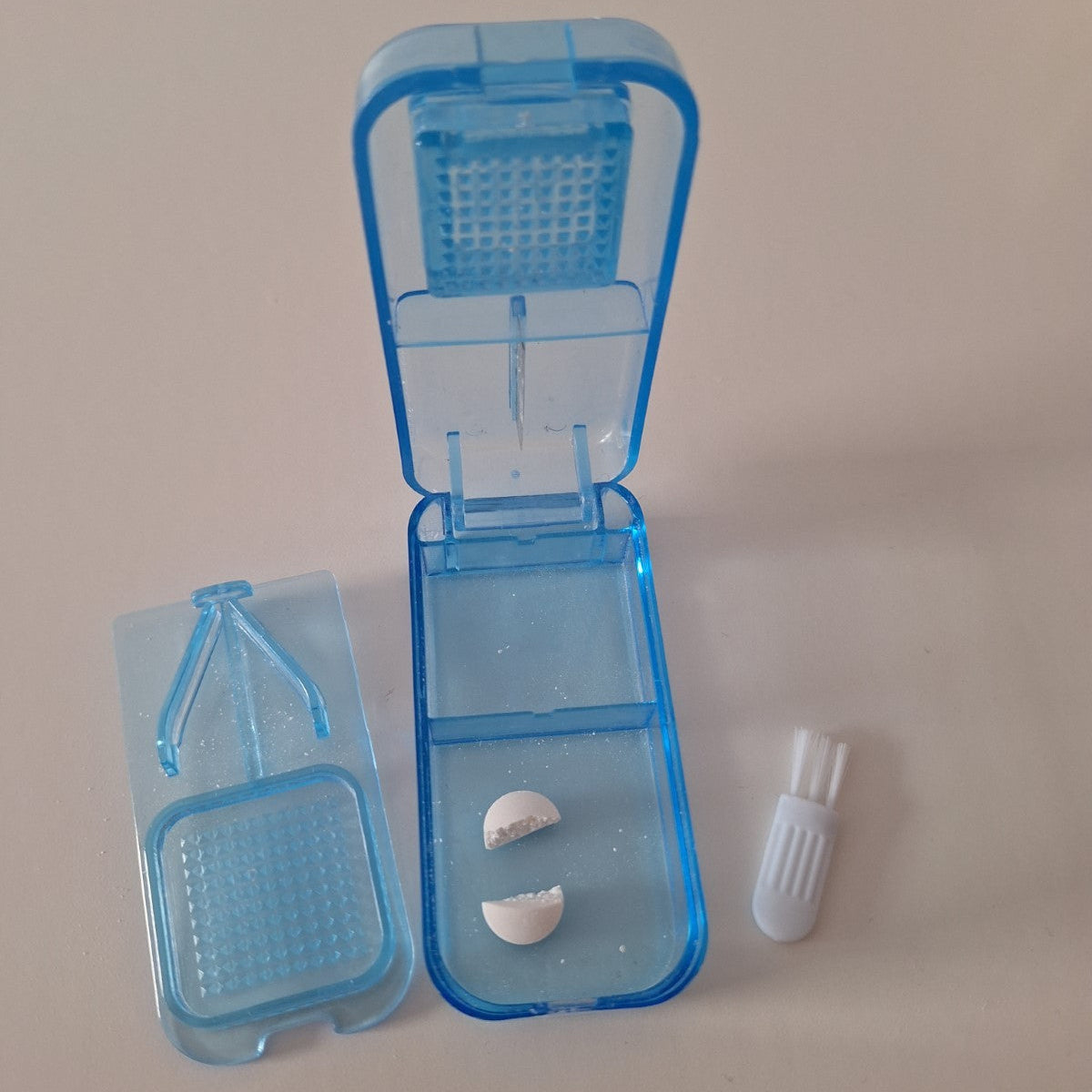 Blauer Tablettenzerteiler mit getrennter Tablette im Fach und Zubehör