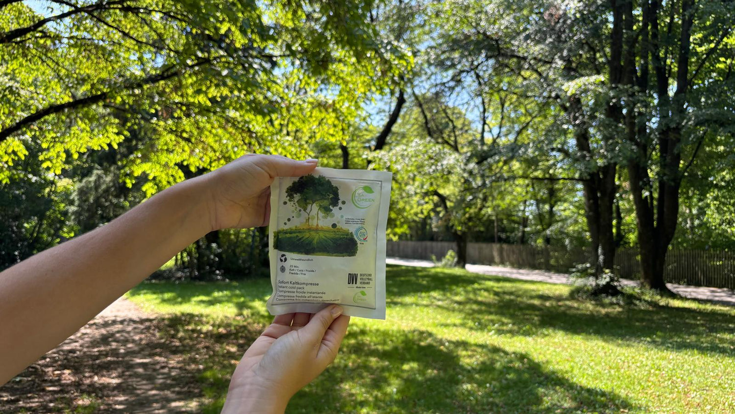 Person hält in der Natur das Produkt Sofortkaltkompresse der Marke IEA Green in den Händen 