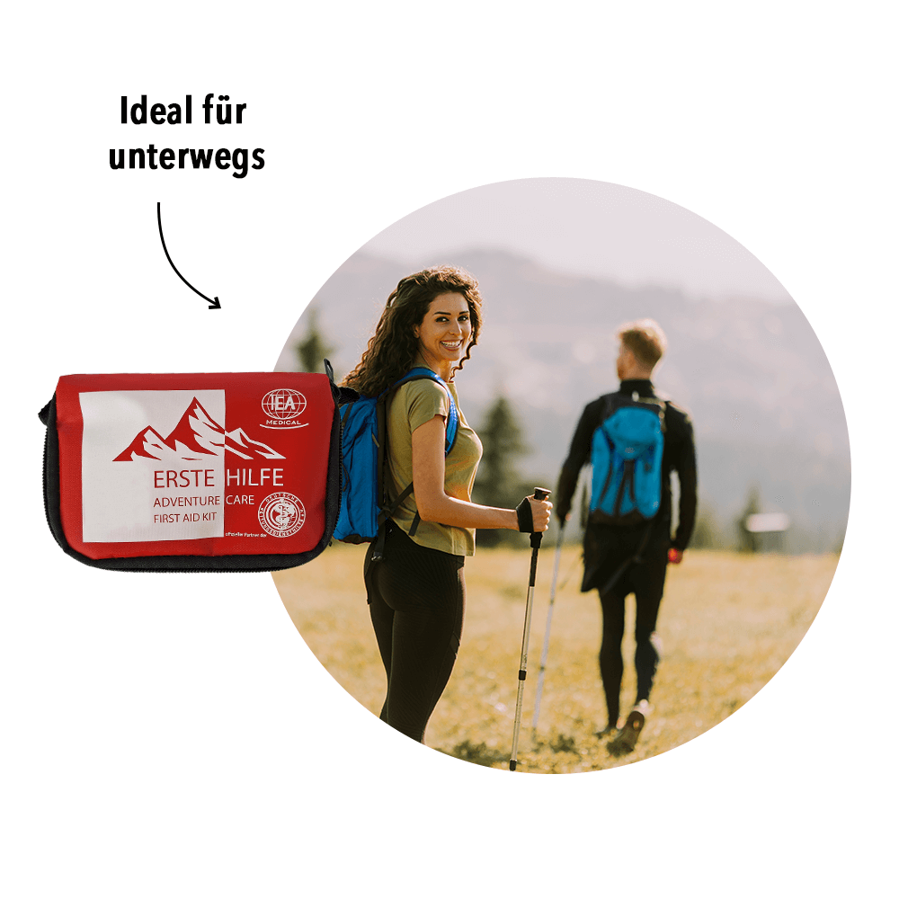 Zwei Personen im Freien; daneben kleine Abbildung der roten Verbandstasche – Aussage: Erste-Hilfe-Set für unterwegs/Wandern.