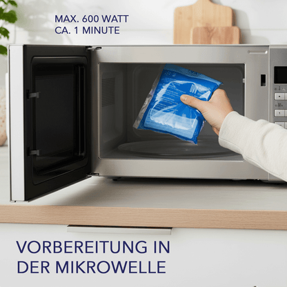 Hand legt blaue IEA Medical Kalt-Warm-Kompresse in eine offene Mikrowelle, Angabe max. 600 Watt, circa 1 Minute.