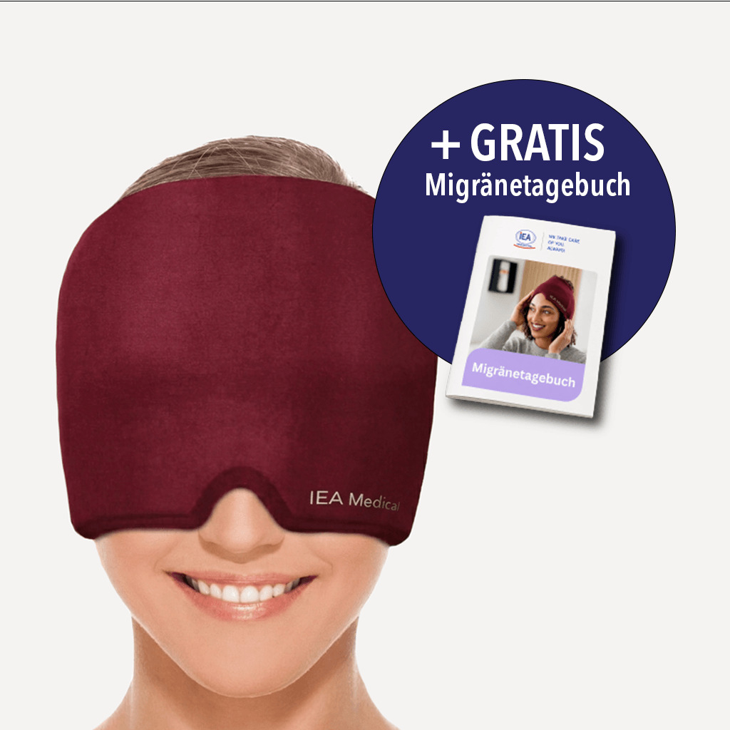 Lächelnde Frau trägt weinrote IEA-Medical-Kopfmaske, die Stirn und Augen vollständig bedeckt. Hinweis dass es die Migränemaske umsonst gibt.