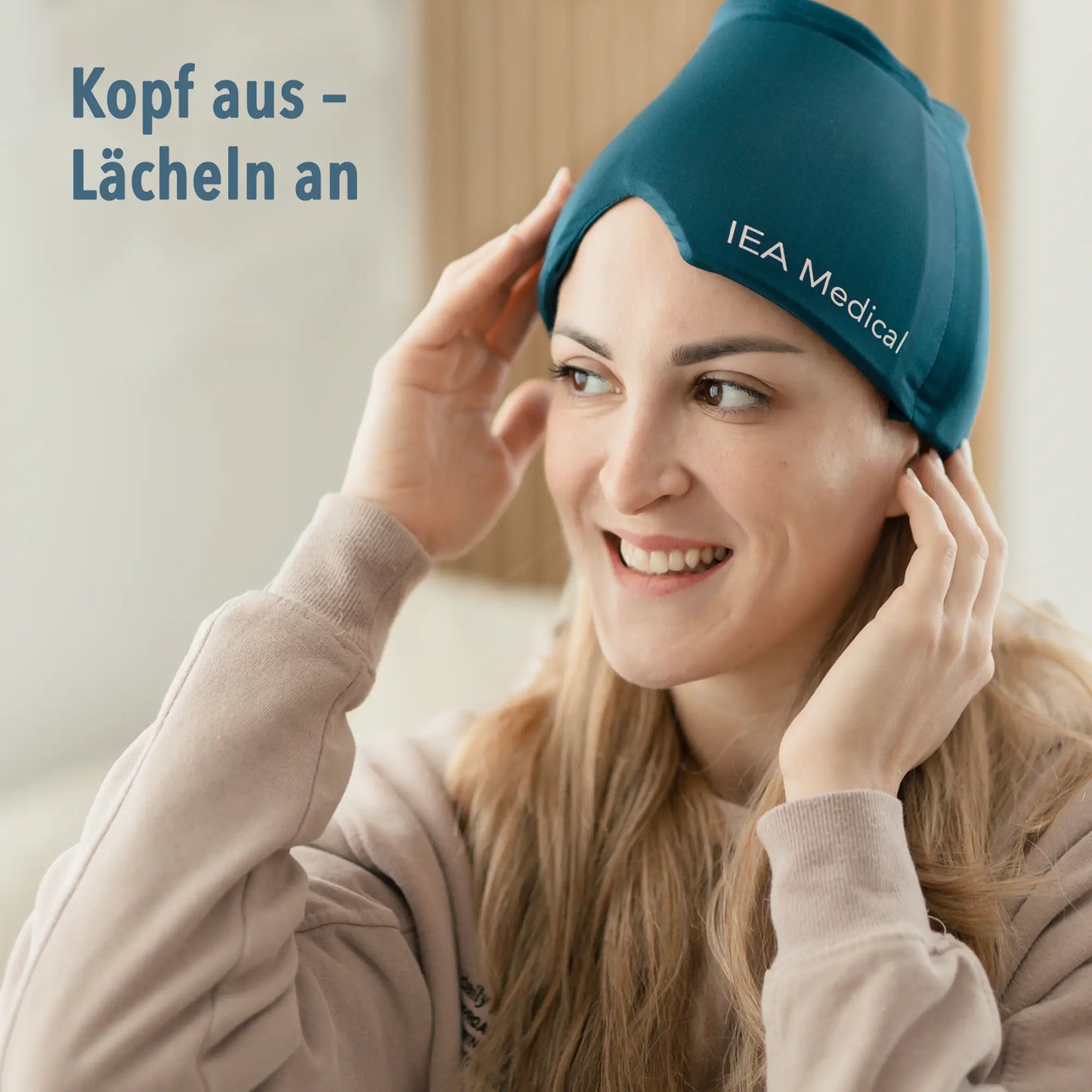 Lächelnde Frau setzt sich eine petrolfarbene Gel-Kopfmaske von IEA Medical auf, Text „Kopf aus – Lächeln an“.