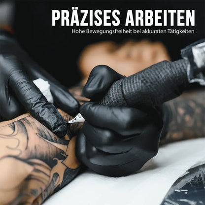 Schwarz behandschuhte Hände bei Tätowierarbeit, Text Präzises Arbeiten, hohe Bewegungsfreiheit bei akkuraten Tätigkeiten.
