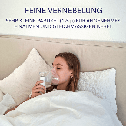Frau inhaliert im Bett mit Maske; Hinweis zur feinen Vernebelung mit Partikeln von ein bis fünf Mikrometer.