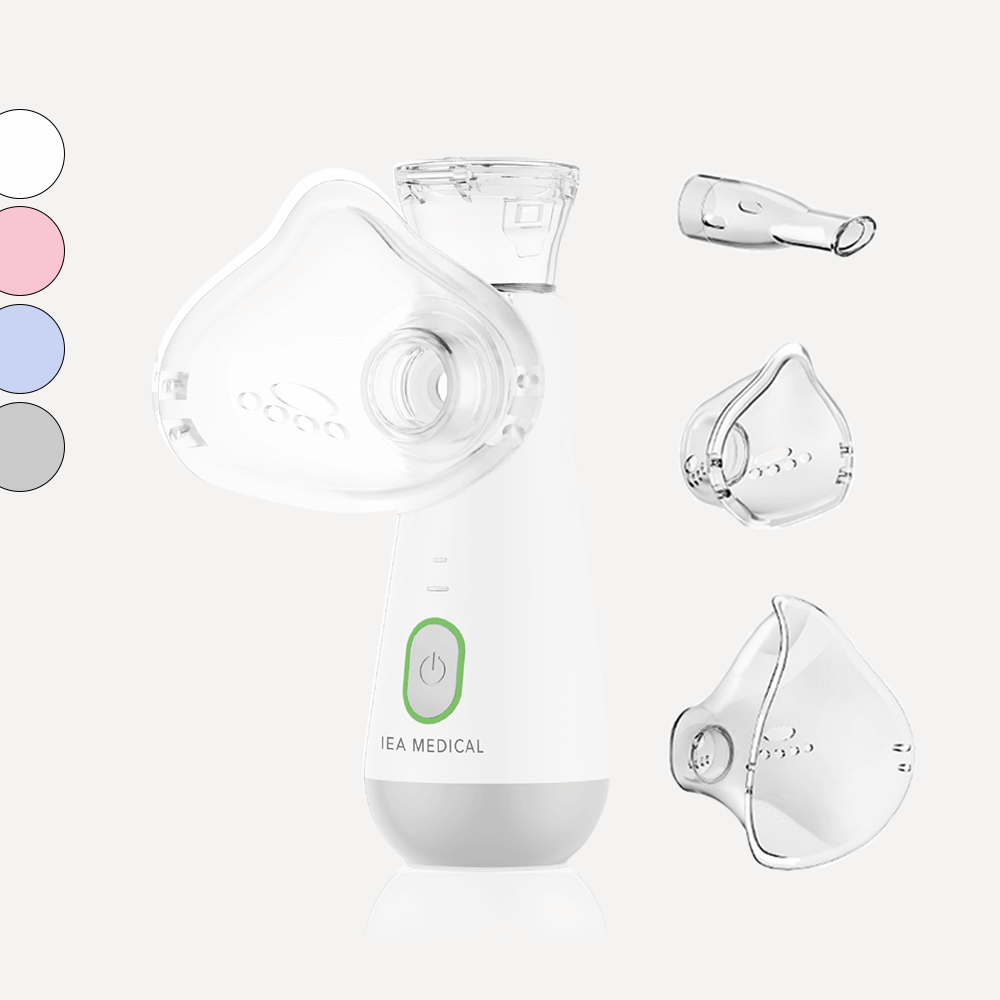 Weißer Inhalator mit grünem Einschaltknopf und Maske, dazu Mundstück, zwei Masken und Farbmuster links.